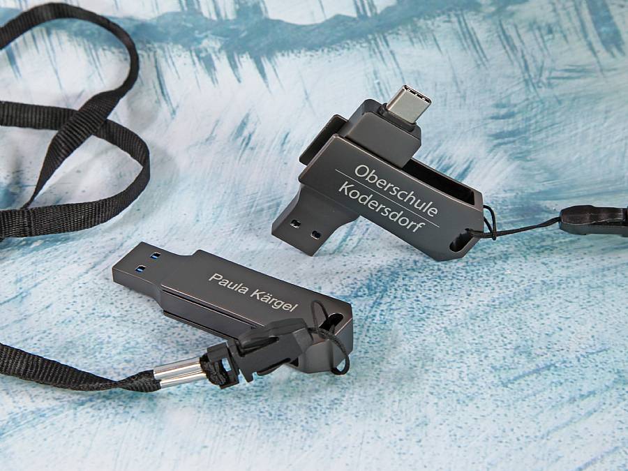 Doppelte USB-Sticks in Schwarz mit individuellem Druck und praktischen Anhängern für personalisierte Nutzung.