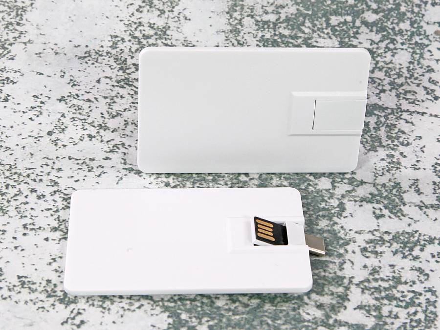Weißer USB-Stick im Visitenkartenformat mit herausziehbarem Anschluss und Platz für individuelle Beschriftungen.